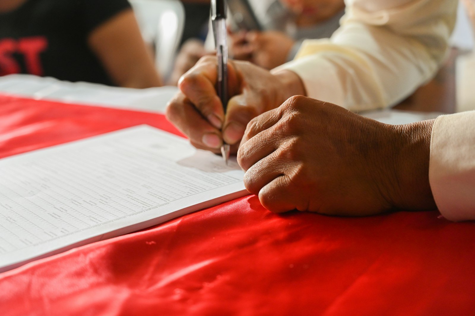 Mano firma un documento sobre una mesa, imagen de referencia sobre el reconocimiento jurídico de un partido
