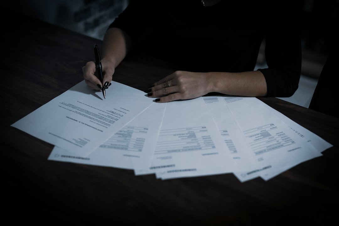 Persona firma un documento en una mesa, imagen referencial sobre la remisión y revisión de expedientes