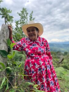 Mujer mayor campesina sonríe en el jardín de su vivienda en Santander, Colombia