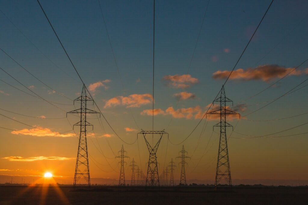 Torres y líneas de transmisión eléctrica al atardecer. Imagen de archivo.