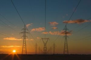 Torres y líneas de transmisión eléctrica al atardecer. Imagen de archivo.